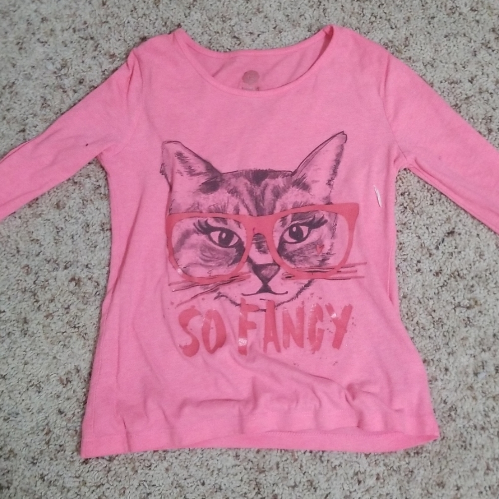 A pink, kids shirt with a cat on it